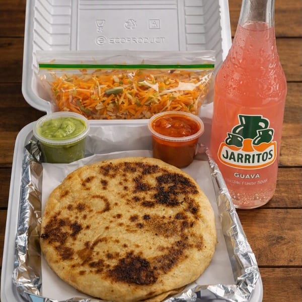 Takeout container with a pupusa, two sauces, pickled cabbage, and a guava Jarritos soda.